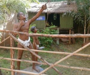 Figures of a father and son hunting for birds with bows and arrows
at the Tribal Cultural Museum in Pune